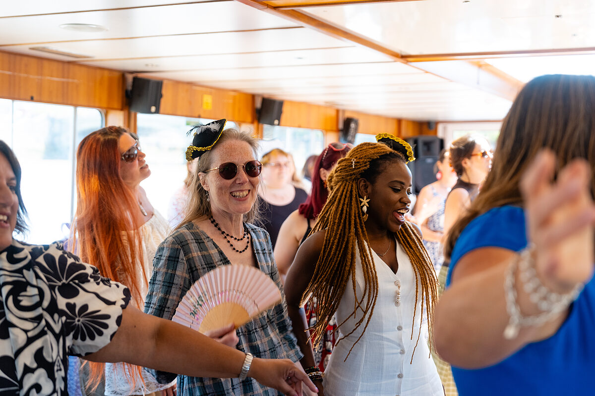 Members of the Female Founders List community laughing and dancing together inside the boat at the boat party